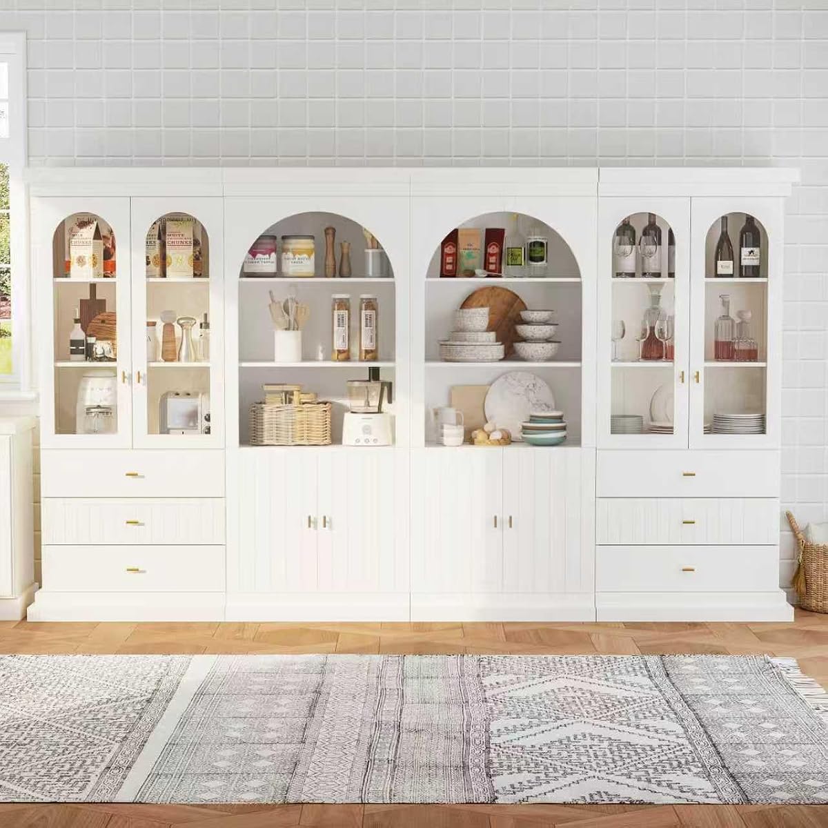 White arched kitchen pantry cabinet with gold handles, dual glass doors and open shelves
