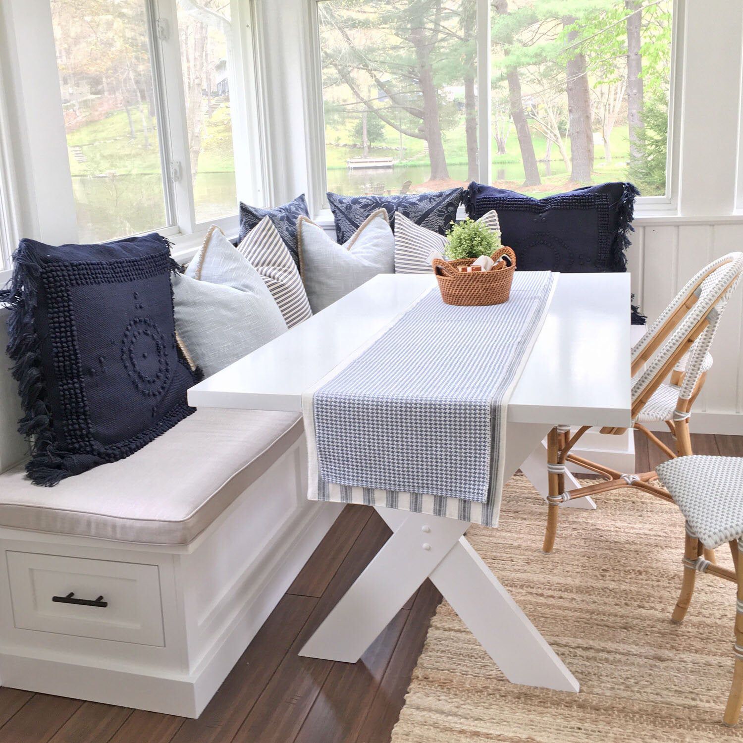 Nautical-themed living room with a white bench, table, and chairs.