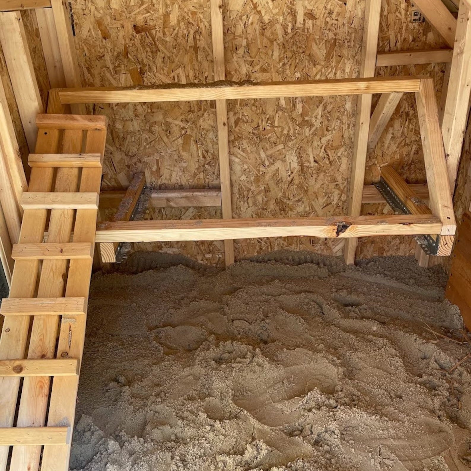 Wooden attic with insulation and a ladder